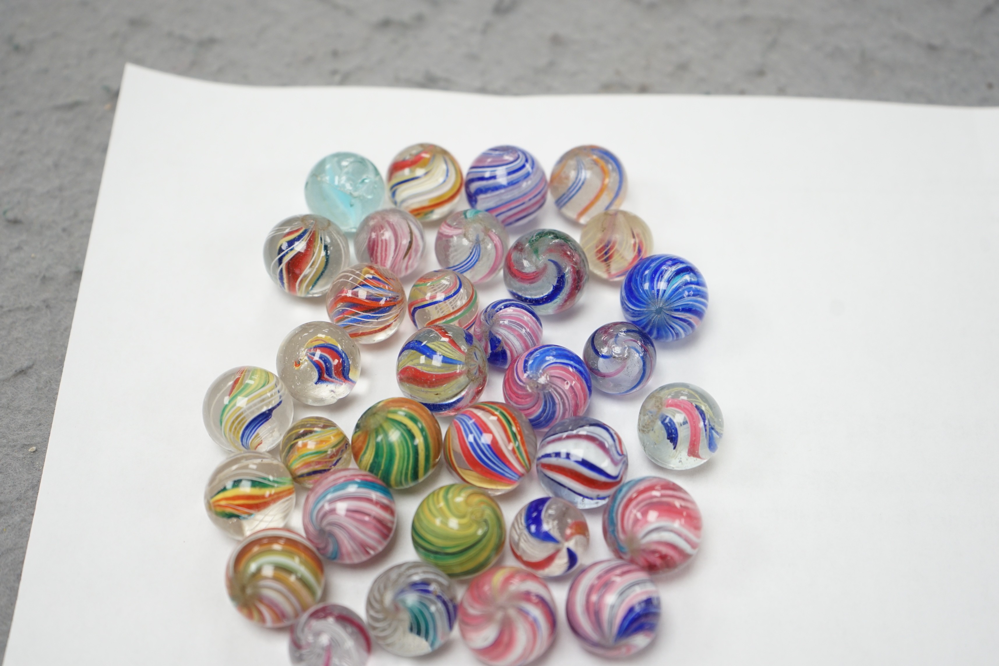 A mahogany solitaire board with a collection of latticino and marbled glass marbles